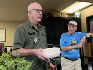 Dennis Wilson showcasing a collection of pots he crafted himself.